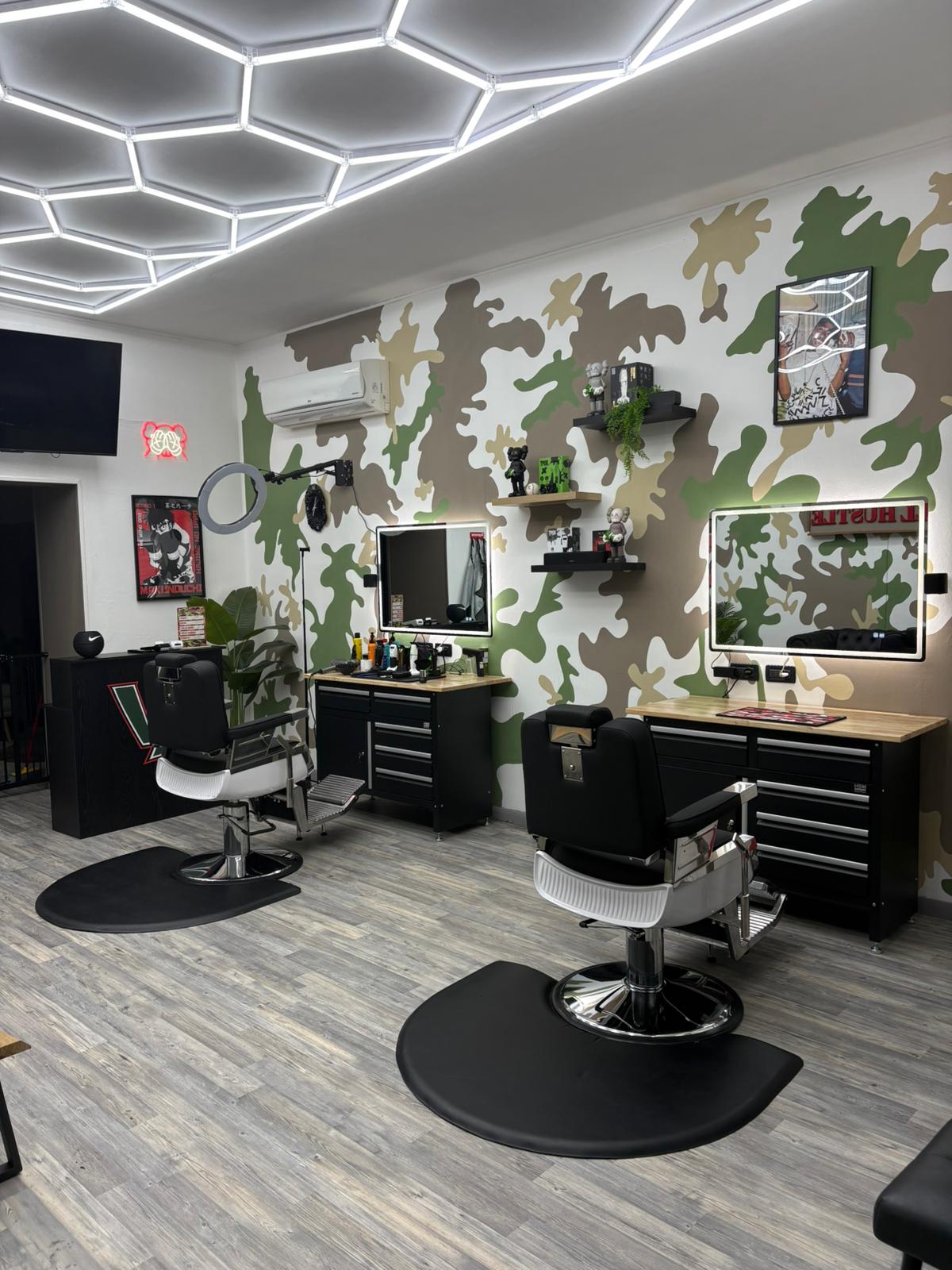 Postazioni da barbiere e parete mimetica di Victory Lap Barber Shop